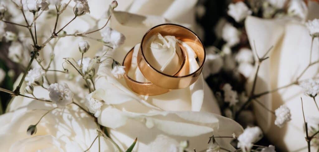 Anillos de boda sobre rosas blancas